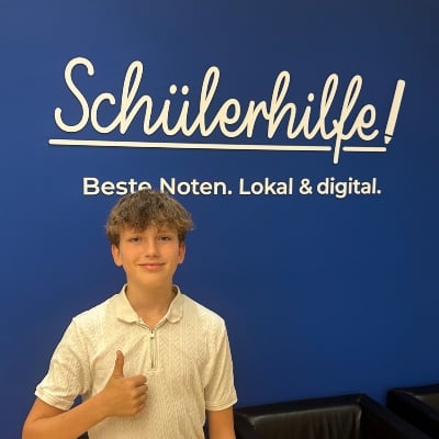 Kind vor Schülerhilfelogo mit Daumen hoch