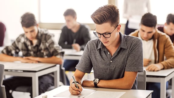 Ein Schüler sitzt in einer Abiturprüfung.