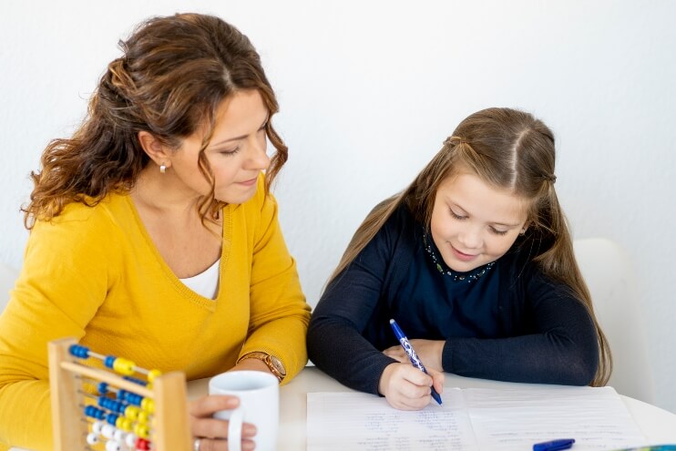 Lehrerin und Grundschülerin aus der 4. Klasse lernen